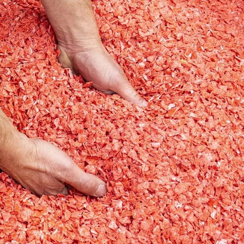 Image of hands picking up red chippings